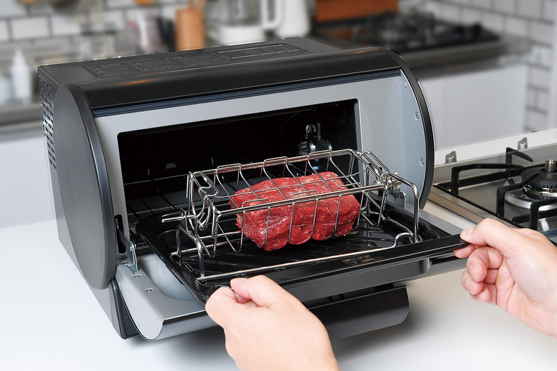 受け皿にセットして本体へ<BR>ロティかごのフック側にある棒を、ロティかご受けの穴に入れ、歯車側を凹に載せる。それを、受け皿にセット。そして本体に受け皿を入れて扉を閉じる