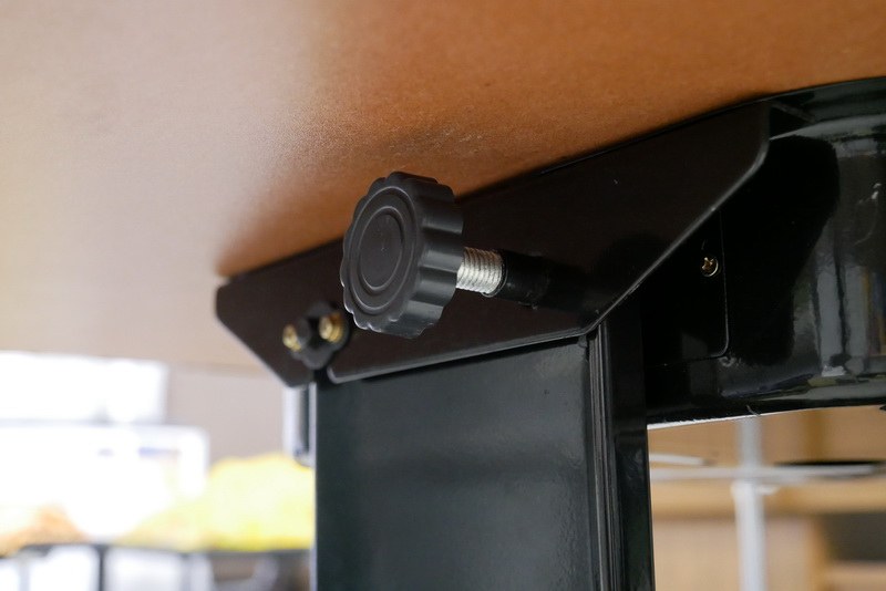 テーブルは下部で2つのネジで固定されており、このネジを緩めることで折りたためる