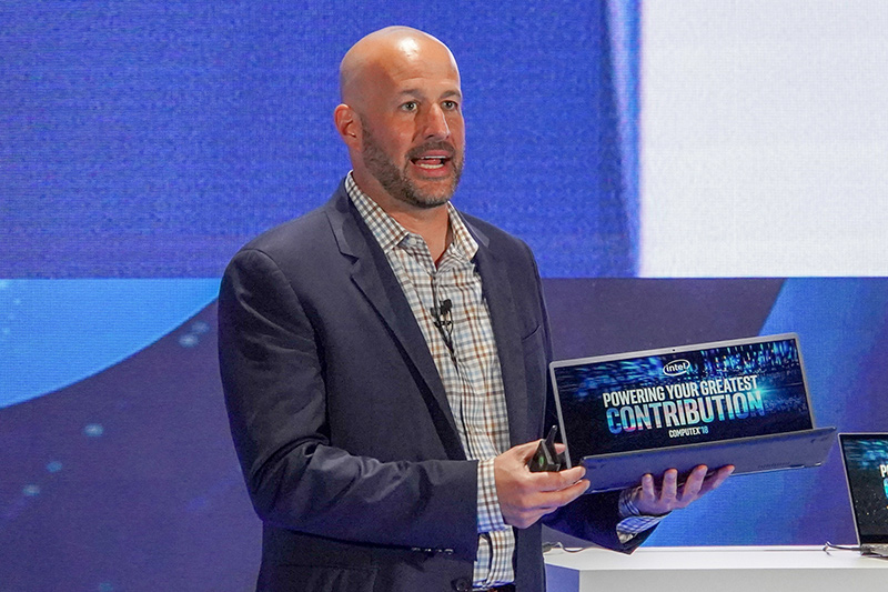 Whiskey Lake-UないしはAmber Lake-Yを搭載したPCを手に持つIntel 上席副社長 兼 クライアントコンピューティング事業本部 事業本部長 グレゴリー・ブライアント氏