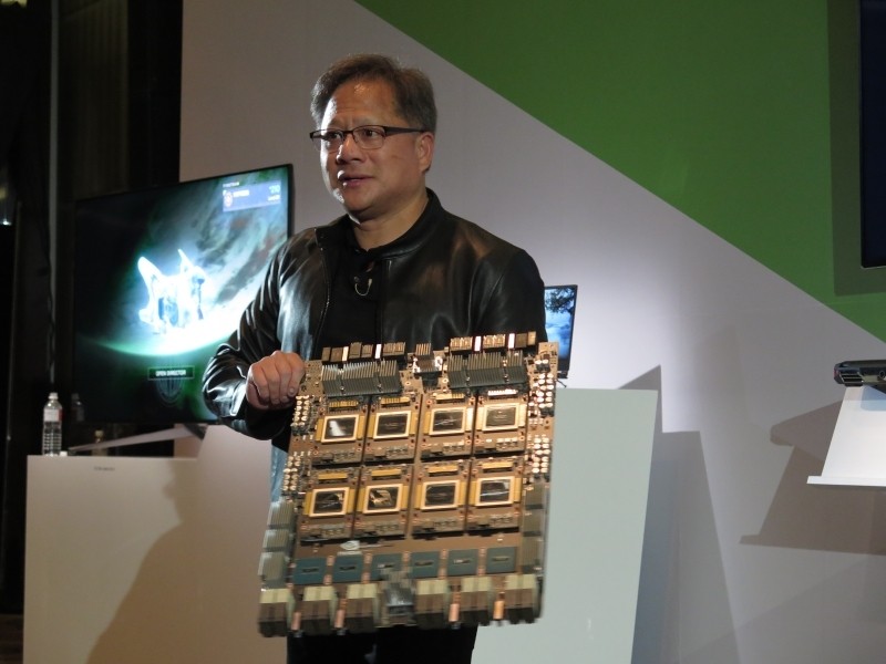 DGX-2のマザーボードを手にするフアン氏