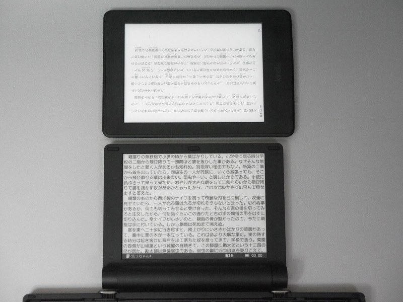 同じく16階調モノクロのE Ink電子ペーパーを採用したKindle Paperwhite(上)との比較。本製品はフロントライトを搭載していないのでこうして並べると暗く見える