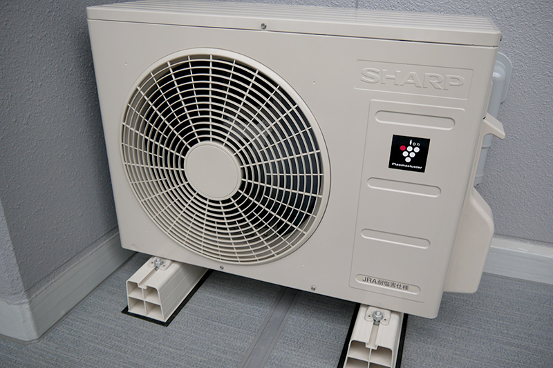 バルコニーに設置されたエアコン室外機。プラズマクラスターのロゴが入っている