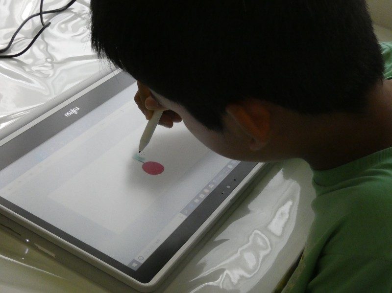 ペンを使ってタブレットモードで絵を描いている息子