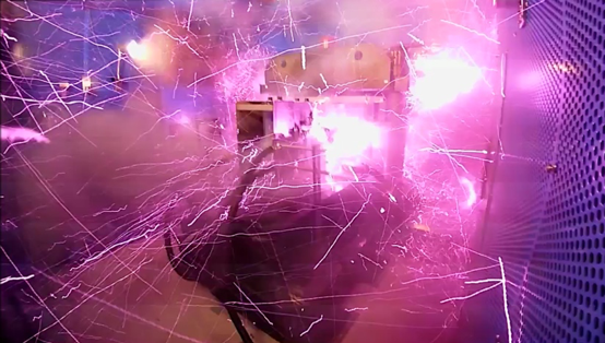 磁場発生瞬後の様子。強磁場発生時には強力なマクスウェル応力がともない、1,000テスラで4×1011N/平方m(400万気圧)に達し、その瞬後に爆発が発生する。そのため装置全体を防護箱(青い壁面)で覆い、磁場発生装置の制御と計測は離れたシールドルームで行なう