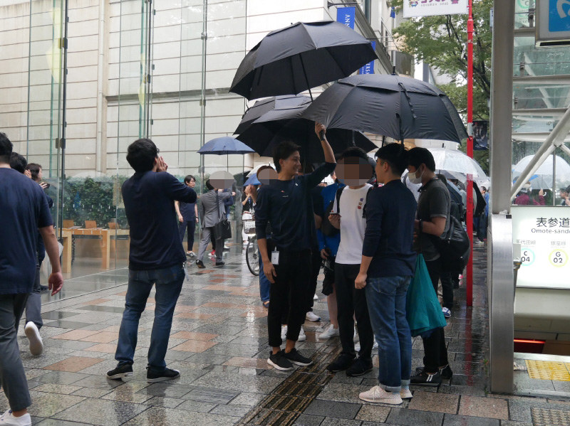 スタッフが一緒になって、傘をさして発売を待つ