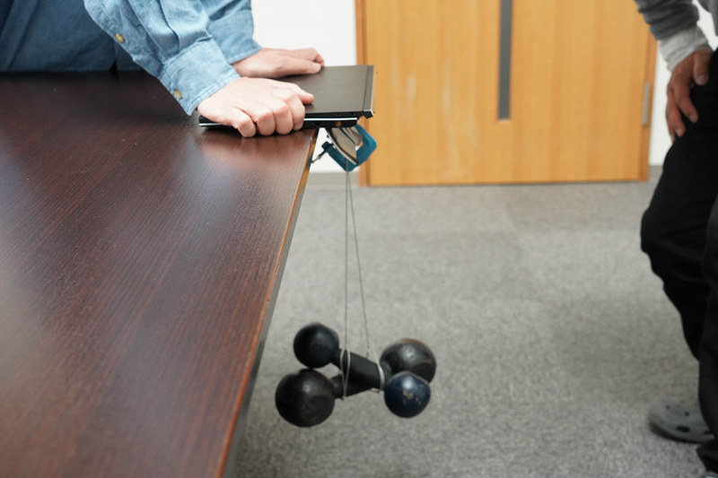 8kgの重りをフラップに吊すテスト(筆者注 : このテストは製品レベルの試作機でのテストであって、実際の製品でこういうことをしても保証されるというものではない。あくまでテストの一環として行なったものだ)