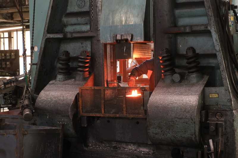 1,000℃に加熱された母材を、手で機械にかけ、タイミングを見計らって2,000tの圧をかけて鍛造。熱間鍛造