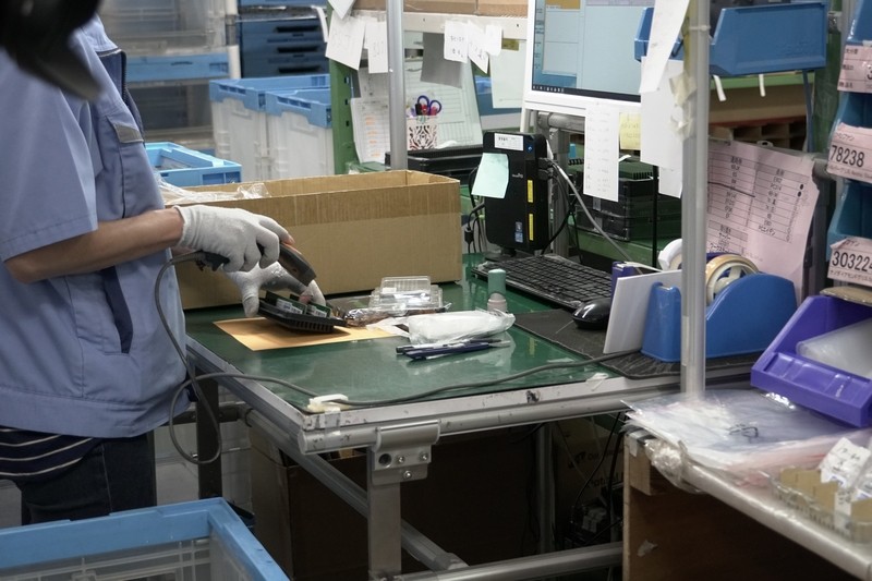 ピックアップした部材が間違っていないかを別の担当者が再確認しつつ、部材ごとのバーコードをスキャンして登録。これによりどのマシンにどのパーツを使ったが個別に把握できる