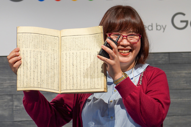 くずし字で書かれた古文書を手に持つ情報・システム研究機構 データサイエンス共同利用基盤施設ROIS-DS人文学オープンデータ共同利用センター 特任研究員 および 国立情報学研究所 タリン・カラーヌワット氏