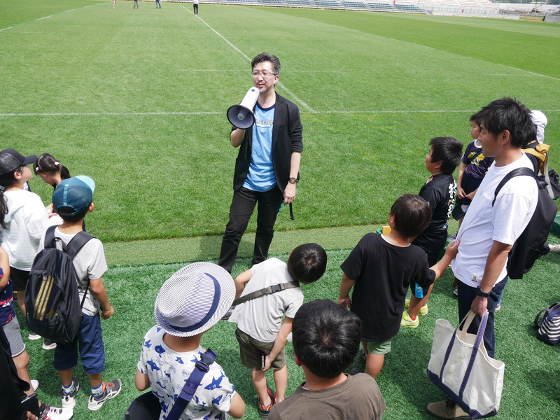 子供たちは、講師を務めたタツナミ・シュウイチ氏とともにフィールドに降りて、スタジアムの様子を見学
