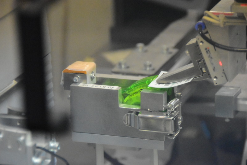 印刷されたシートにノリをつけるという繊細な作業をロボットが行なう