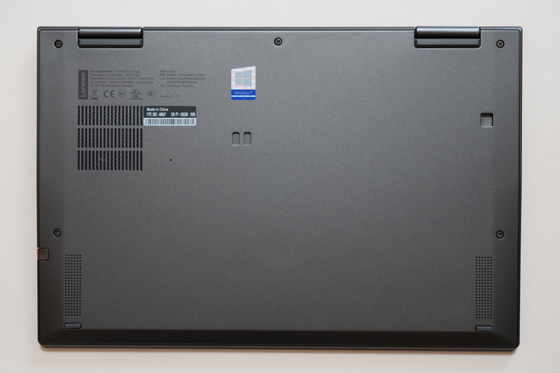 本体底面(上がヒンジ部)。冷却口の右にある小さな穴はリセットスイッチ。3つあるへこみはドッキングステーション固定用の穴だ。両側面下部にはおもに低域を再生するウーファーが内蔵されている