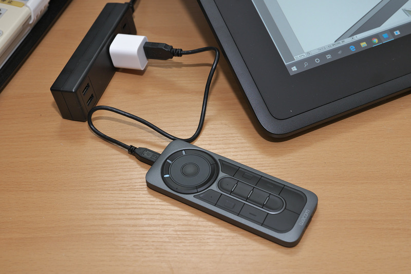 別売オプションの<a href="https://store.wacom.jp/products/detail.php?product_id=2775" class="n" target="_blank">ExpressKey Remote</a>(直販価格 : 13,824円)はワイヤレス接続なので、充電以外でUSBにつなぐ必要はなし。でも、なんとなくとつぜん切れるのがイヤ、ということで横にUSB給電器を持ってきて使っていたざら先生