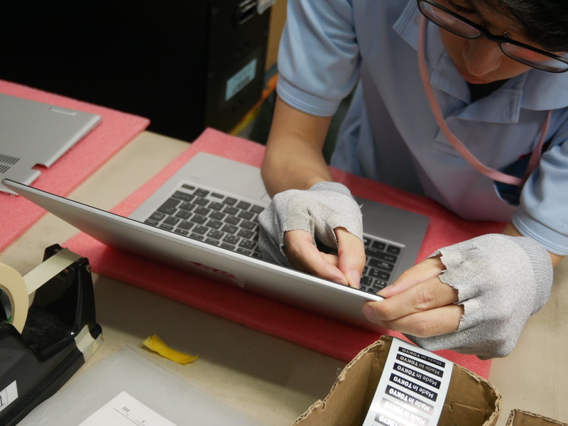 こちらは、ノートPCに「Made in TOKYO」のシールを貼付しているところ