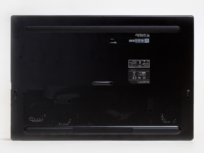 裏には前後に1本バー式のゴム足。手前左右のスリットにスピーカー