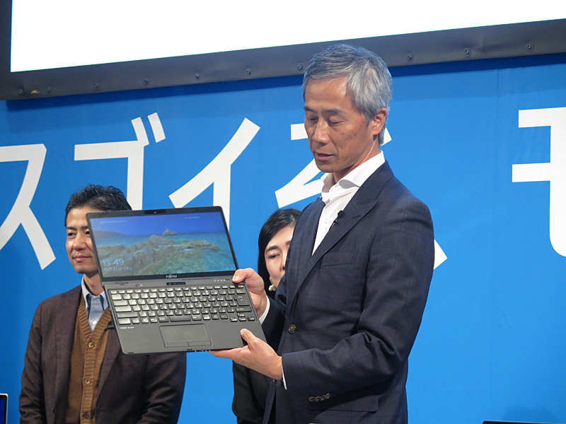 富士通クライアントコンピューティング株式会社 執行役員 新規事業本部長 兼 コンシューマ事業本部 副本部長 高嶋敏久氏。「LIFEBOOK UH95」をアピール。2in1で世界最軽量の約868gを実現し、「うちわ代わりにあおげる」という。収納可能なペンや、タブレット形状時に使える背面カメラの利便性を謳う