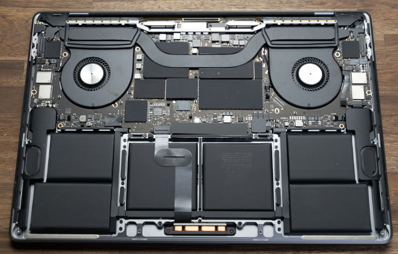 MacBook Pro 16インチモデルの内部。ヒートパイプが左右に走っているが、その真下にGPU(左側)とCPU(右側)が配置されている。ヒートパイプからやや離れた場所にメインメモリやVRAMが実装されているが、各チップには放熱用素材が貼りつけられているため、直接型番などを確認することはできない
