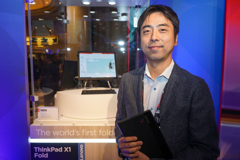 レノボ・ジャパン株式会社 大和研究所 システムイノベーションコマーシャルノートブック開発部長 兼 主任エンジニアの塚本泰通氏。背後および塚本氏が手に持っているのは同氏が開発を主導するThinkPad X1 Fold