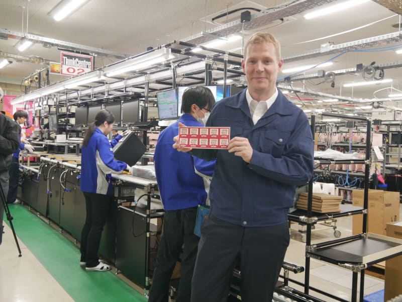 ThinkCentreの生産ラインでJAPAN MADE & SUPPORTのシールを持つベネット社長