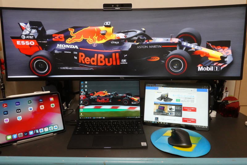 筆者の仕事用デスク。中央にあるXPS 13で記事などを書いている。背面のU4919DWはおもに資料を表示したり、別途接続してあるゲーミングPCでゲームするときに使っている。Creativeのマークが入っているカメラはIntelのRealSenseカメラで、ゲーミングデスクトップPCでのWindows Helloのログイン用に使っている