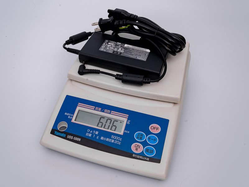 ACアダプタは180W仕様。スリムなフォルムで、実測のサイズは75×144×23mm(同)