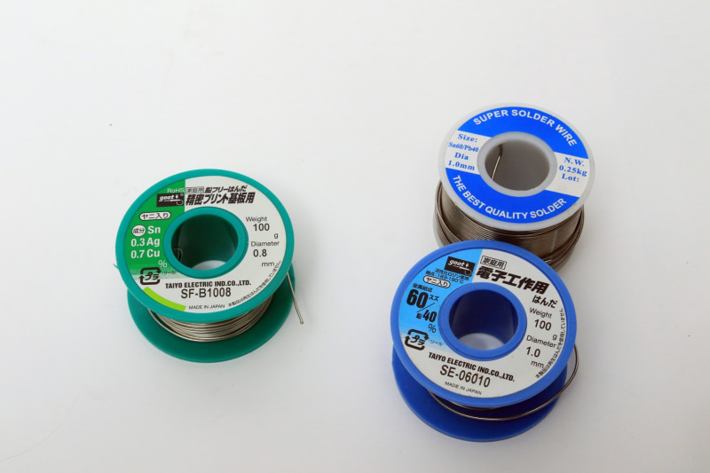 鉛フリーはんだは環境に優しいが、作る人に厳しいので、フツーの鉛入りのはんだがオススメ。左の緑色は「鉛フリーはんだ」とある。Pbや鉛と表記のある青いほうが鉛入り