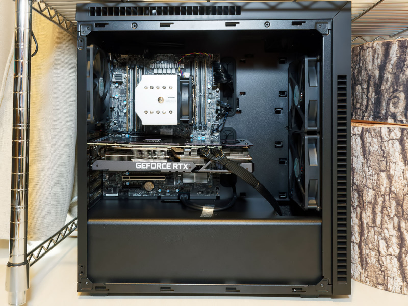 下側の黒いカバーの奥にHDDマウントと電源が収められている。冷却風の経路をわけることで、CPU+GPUの熱い排気の影響を受けにくくなっており、結果として電源の長寿命化にもつながる