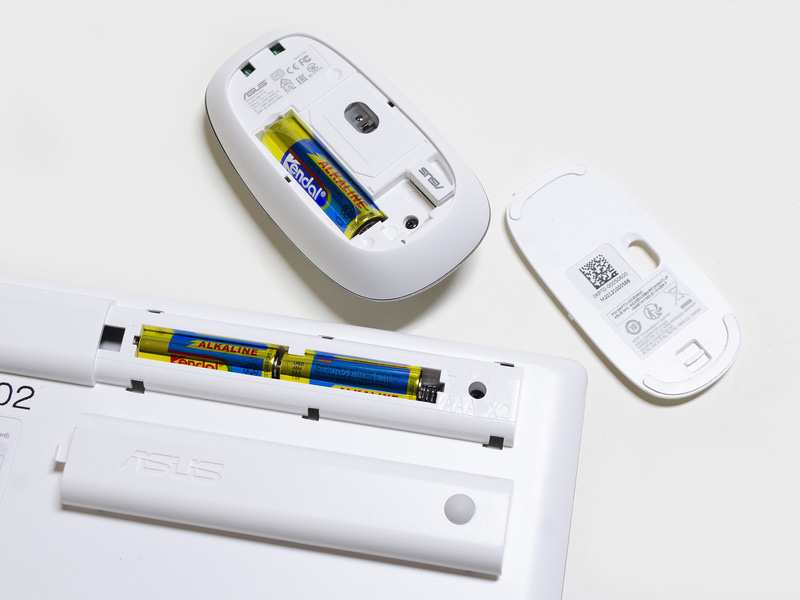 キーボードとマウスの裏側。バッテリはキーボード側が単4形×2、マウス側が単3形×1。マウス側にUSBのドングルを収納