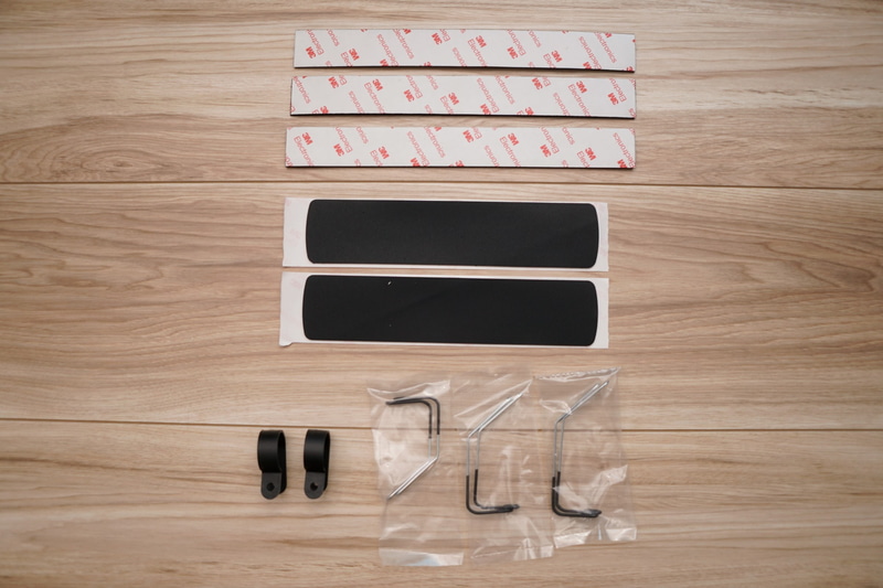 付属品。上の3Mと書かれたのがドックを貼りつけるための両面テープ。その下の黒いのがノートの滑り止めのテープ。右下のものは、ドックやノート本体をトレーに固定するための針金