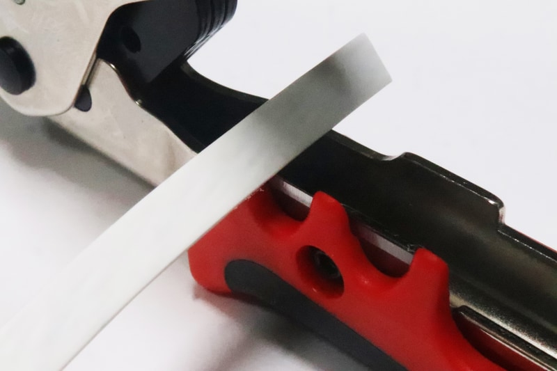 LANケーブルをフラット用の刃にあわせる。フラットケーブルは通常の丸いケーブルに比べると、外側の被覆が剥きにくい。長く剥くなら何回かに分けるといい