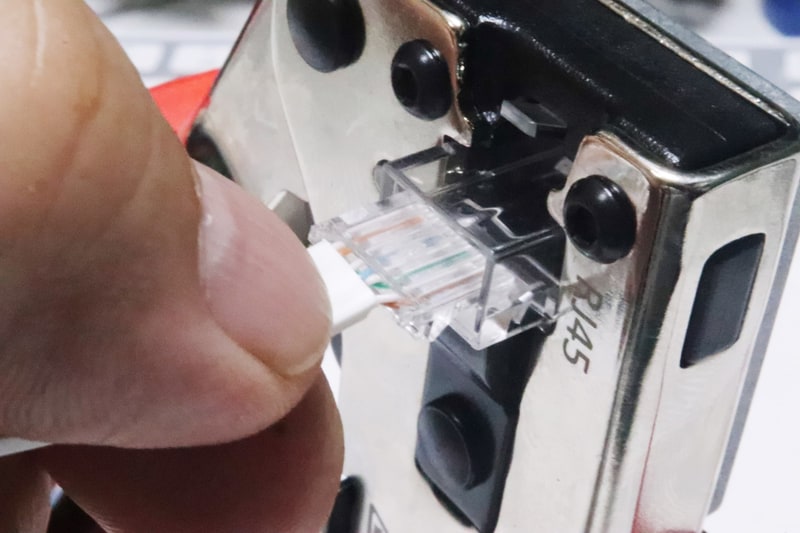 かしめ工具にあらかじめRJ45コネクタを差し込んでおくと作業しやすい。続けてロードバーを差し込む。一度差し込んだロードバーを抜くと電線が抜けてしまうので注意。後戻りせずそのままかしめる