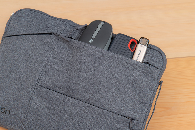 表面右上の大きいほうの横長ポケットはマウスやSSD、USBメモリなどの周辺機器を収納するのに適している