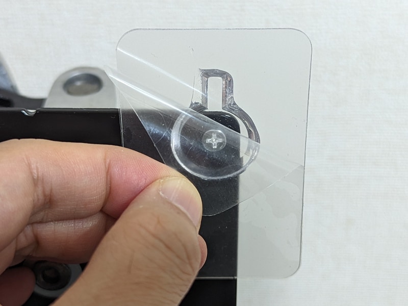 続いて裏の粘着テープをはがし、そこに保護ケースを押し当てるようにして貼り付ける