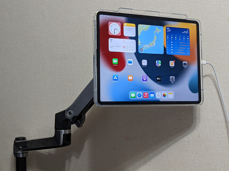 ディスプレイアームに取り付けた状態。充電ケーブルはL字もしくはU字コネクタの製品に交換してアームに沿わせれば目立たなくなるだろう