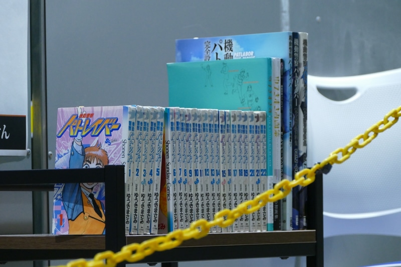 並べられたコミックスやムックは金岡博士の私物