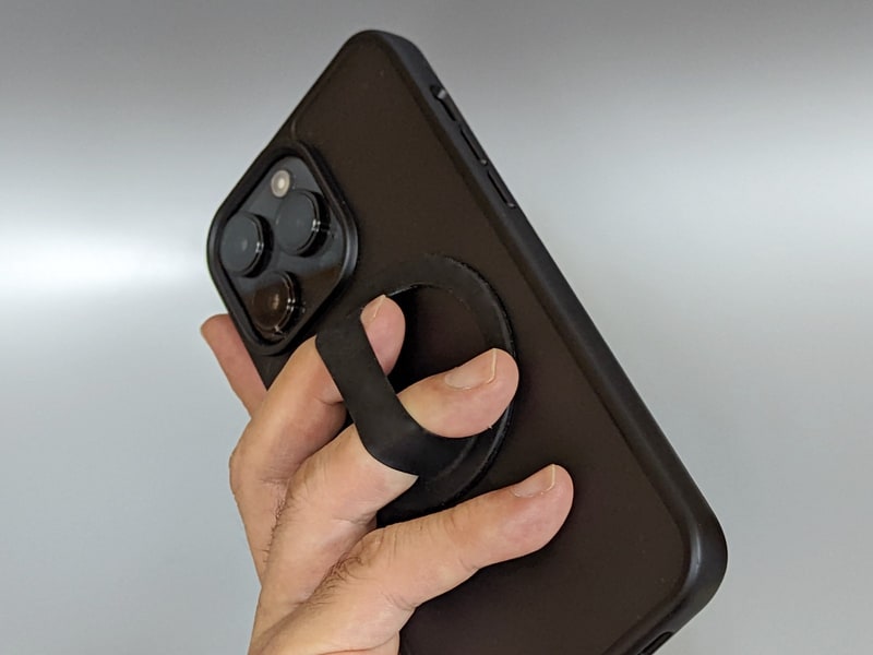 保護ケースの背面に貼り付けたままMagSafeも使えるシリコンゴム製のグリップ。寝転がって顔の上にかざしての読書も快適だ