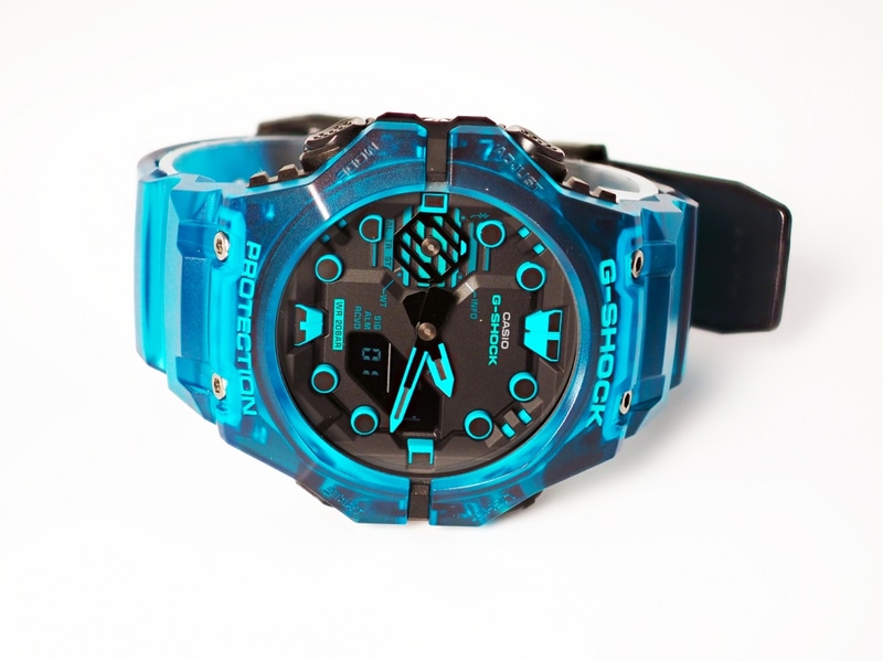 文字盤には近未来のセキュリティロックをイメージしたという幾何学形状のデザインが施されている。通常、数字が持ちいられるインデックスがサイバー空間のトンネルゲートの入り口のような丸形になっているのがユニーク。ブラック×ブルーのスケルトンカラーは、サイバーバーチャル空間のイメージにピッタリだ