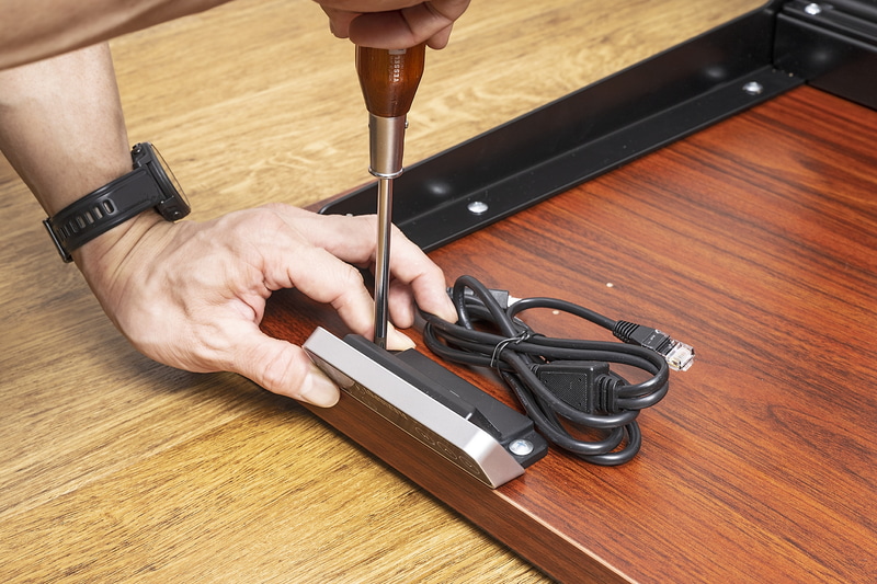 リモコンの取り付け。デスクの左右どちらにも固定用の下穴があるので、好きな方に