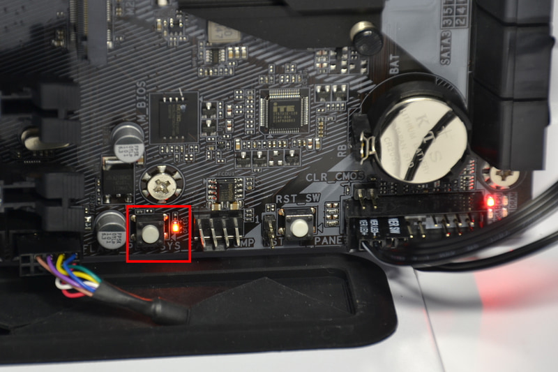 マザーボードの下方に「Q-Flash Plus」ボタンがある(赤枠の白いボタン)。押すとすぐ右側にある動作ランプ(QFLED)が点滅する