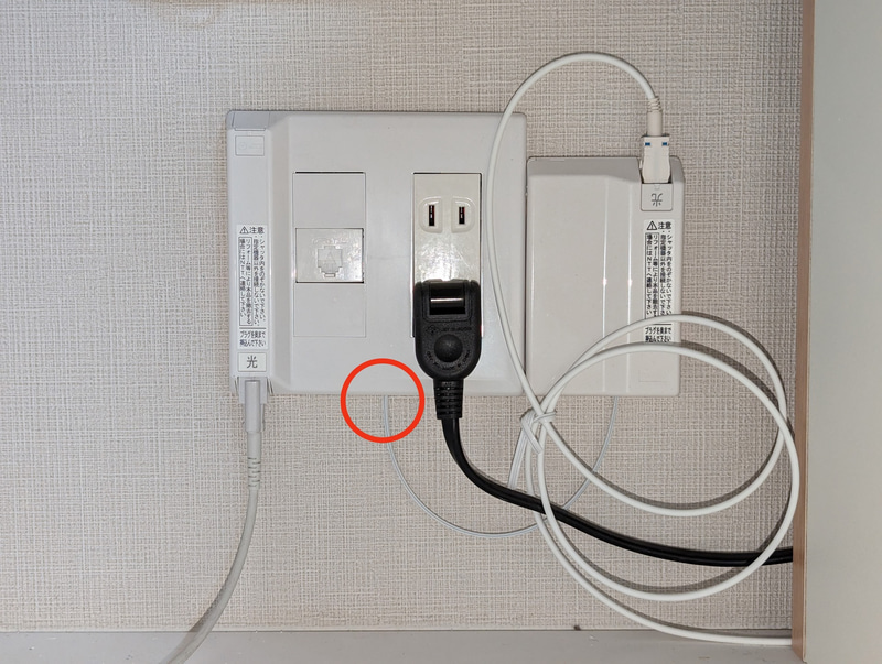 左側の「光」と記されたケーブルはもともとの光ファイバー。この光コンセントの中から、増設した光ファイバーを引き出し(赤丸のところ)、もう1つの光コンセントを右側に増設した。やや無理やり感はあるが、言われなければさほど不自然ではないし、2回線を引くときは基本的にこうなるらしい