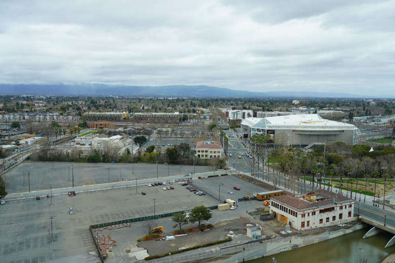 ファウンダーズタワーから見たカルトレインのサンノゼ・ディリドン駅(中央左よりの赤い建物が駅)、右側に見えるのはスタジアム(SAPセンター)でコンサートやNHLのゲームなどに使われている