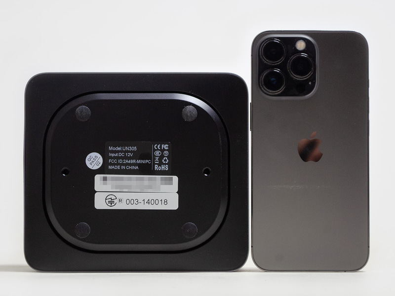 裏面とiPhone 13 Pro。楕円の四隅にゴム足、その内側にVESAマウンタ用にネジ穴