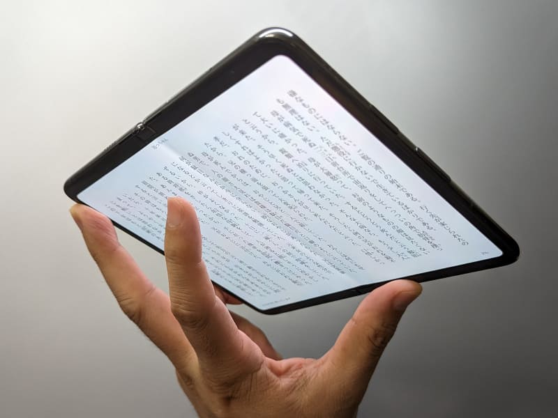 寝転がった状態で頭上にかざして読書する場合は、完全に広げた状態で3本指で本体を支え、人差し指でめくるという、6～8型デバイスと同じスタイルが使える