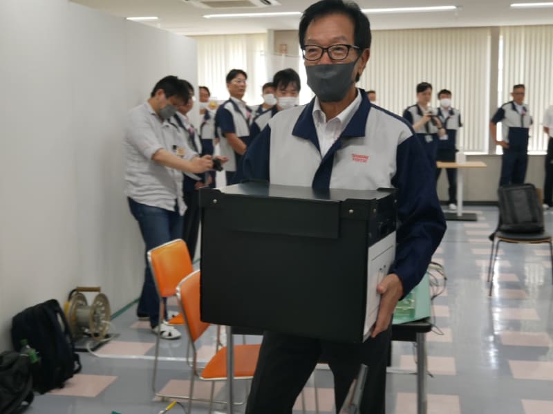 齋藤会長も部品ケースを受け取り、作業机に運ぶ