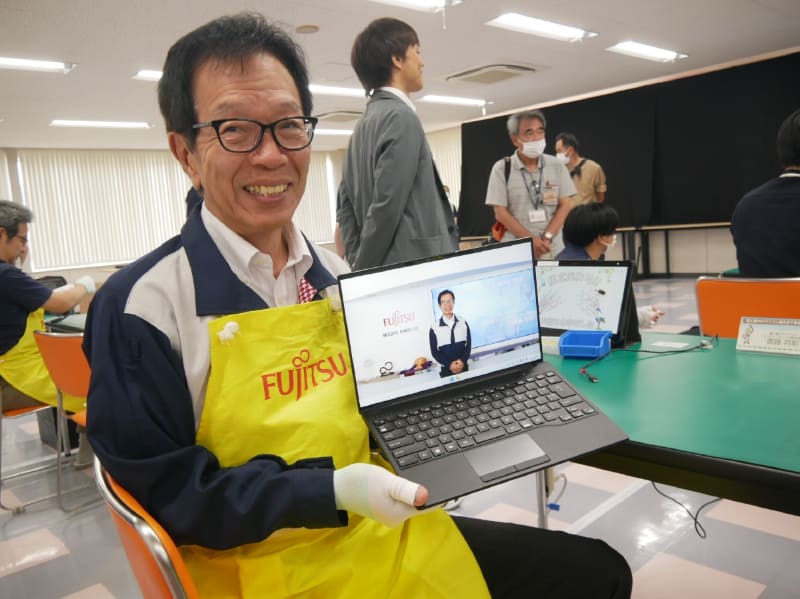 完成したLIFEBOOK WU-X/H1を手にする齋藤会長