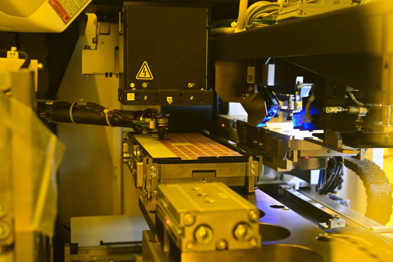 ダイヤモンドカッターを利用して、ウェハがダイに分割されていく。分割されたダイはロボットアームが自動でトレーに置いていく