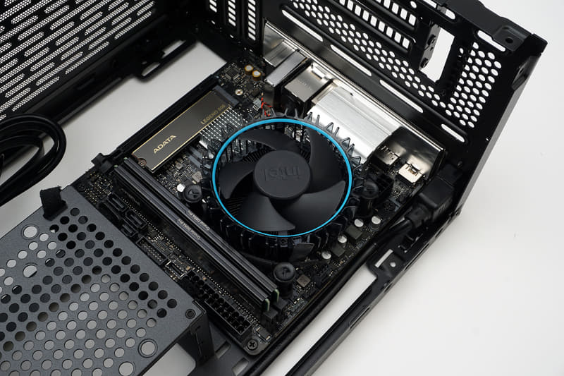 マザーボードにCPU、CPUクーラー、メモリ、SSDを取り付ける。そして、PCケースにバックパネルカバーを取り付けた後、マザーボードを固定する