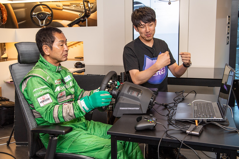 レーシングスーツに着替えた土屋氏、ハンドルコントローラーに慣れていないと言いつつ、コースをクリアする。ゲーム中はとにかくディスプレイに表示される映像がきれいなことに感心していた