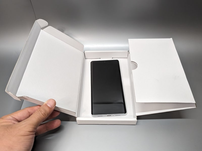 開封してスマホを入れる。サイズ的に本体しか入らず、付属品を入れる余地はない。ちなみにこの写真ではダイレクトに入れているが、厚紙が重なった右側の部分に挟んで内側に折りたたむのが正解らしい