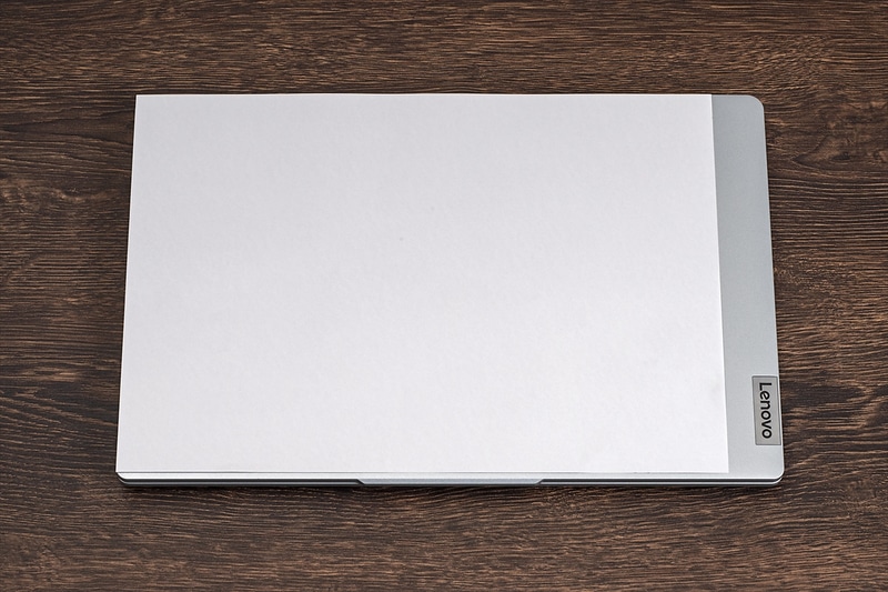 A4用紙を上に載せてサイズ比較。14型ディスプレイ採用のため横幅は少し大きいが、奥行きはほぼA4サイズに収まるコンパクトさ